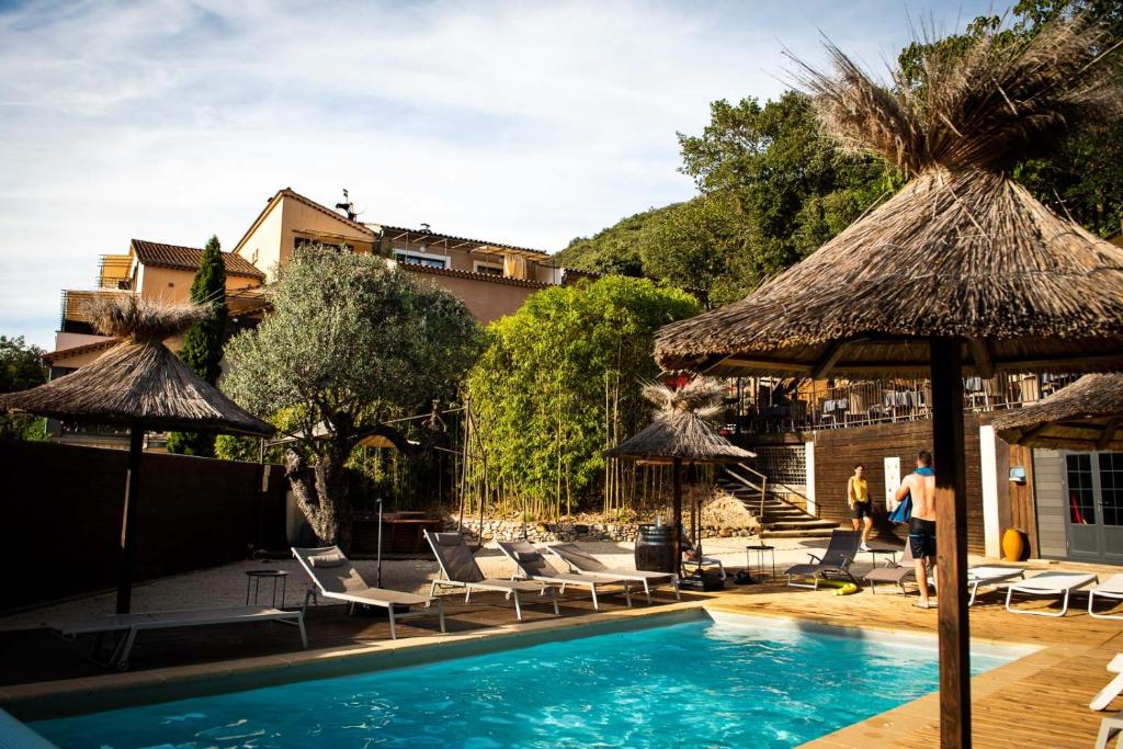 una piscina con sillas y sombrillas en Le Belvedere, en Vallon-Pont-dʼArc