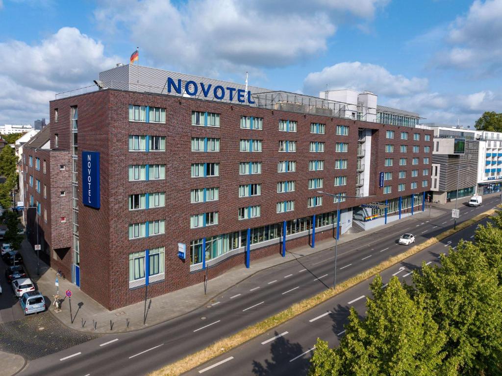 um grande edifício de tijolos vermelhos com um sinal nele em Novotel Köln City em Colónia