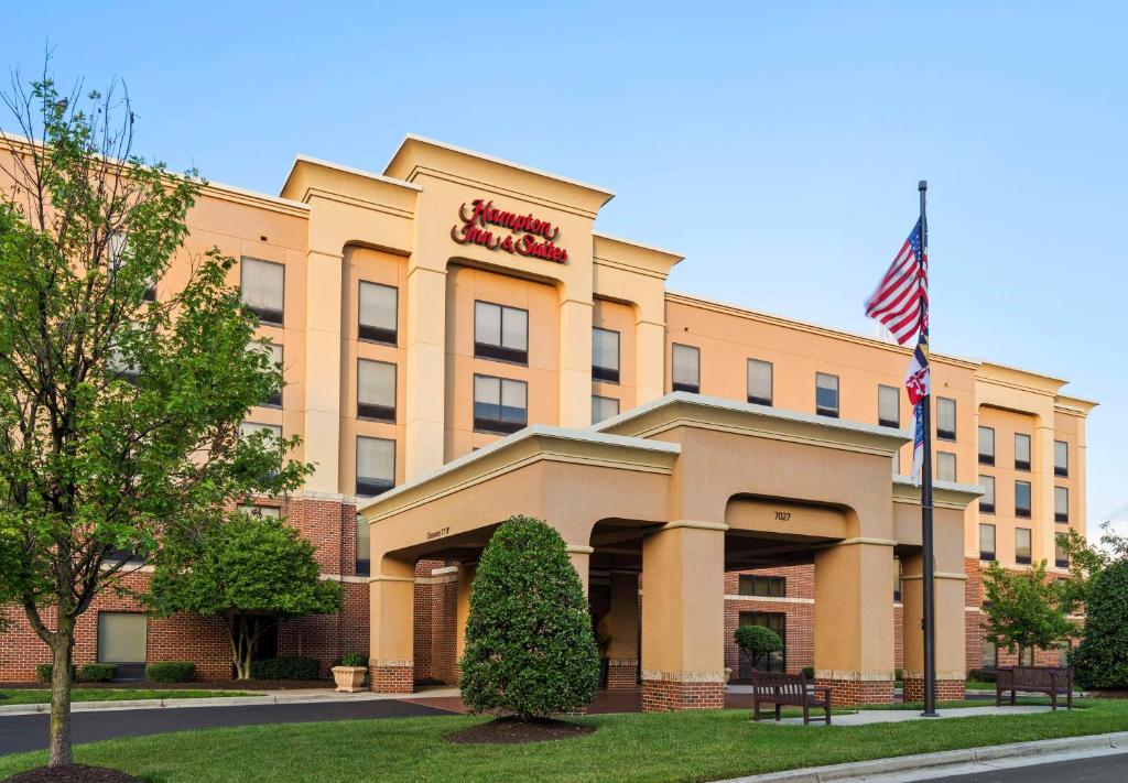 Hampton Inn & Suites Arundel Mills/Baltimore في هانوفر: اطلاله اماميه على فندق مع العلم الامريكي