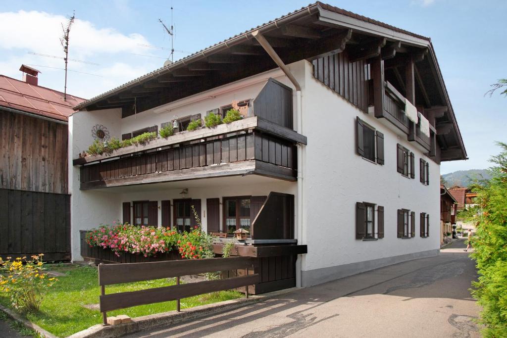 - un bâtiment blanc avec un balcon orné de plantes dans l'établissement Ferienwohnung Reindler, à Fischen im Allgäu