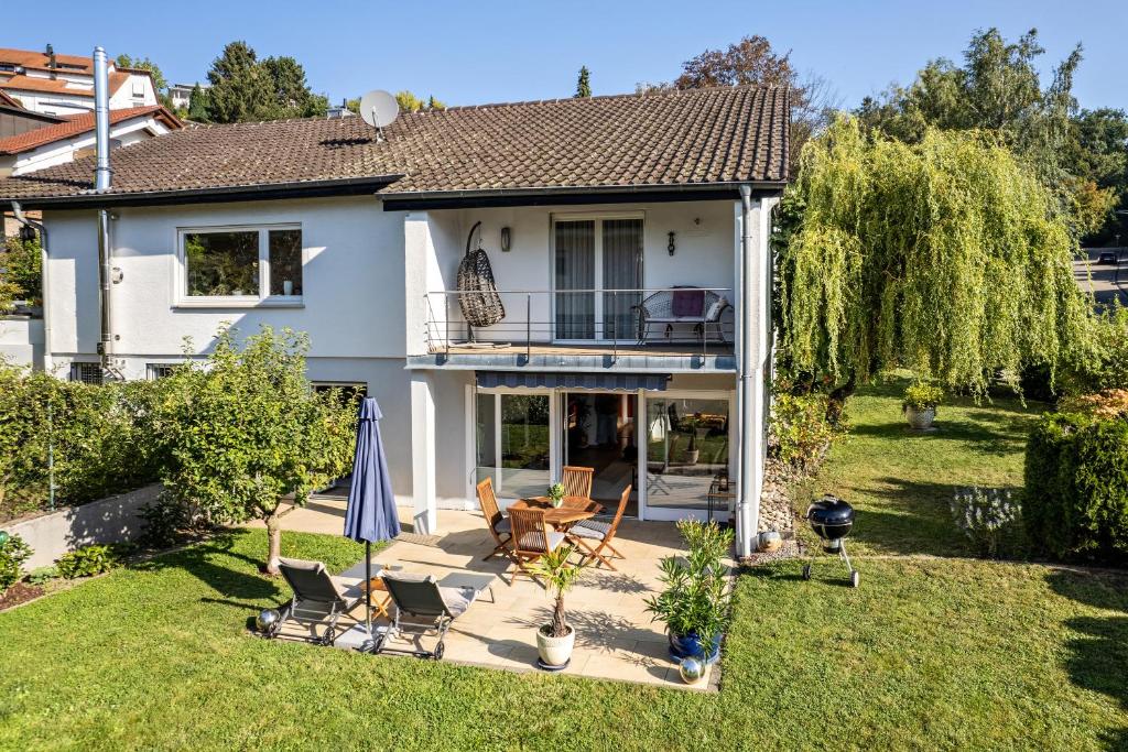 een huis met stoelen en een parasol in de tuin bij Ferienwohnung Kuckucksnest in Lahr