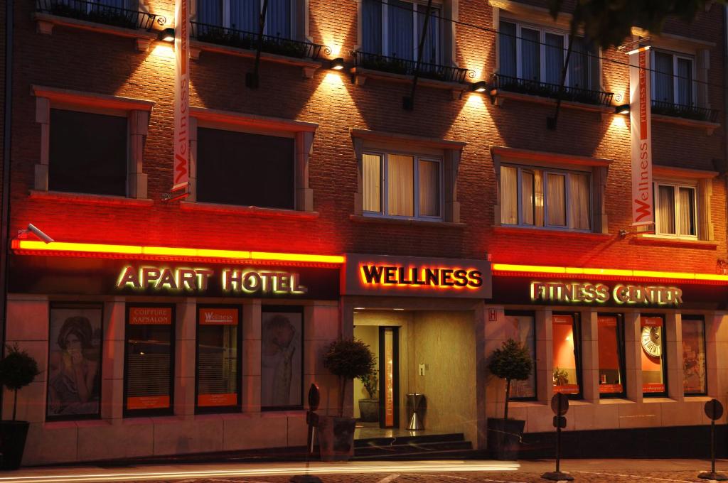 een hotel met neonborden aan de zijkant van een gebouw bij Wellness Apart Hotel in Brussel