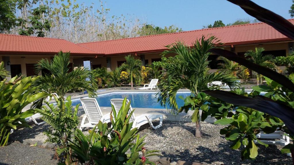 een resort met een zwembad met stoelen en palmbomen bij Hotel D'Lucia - Quebrada Ganado, Jaco, Costa Rica in Puntarenas