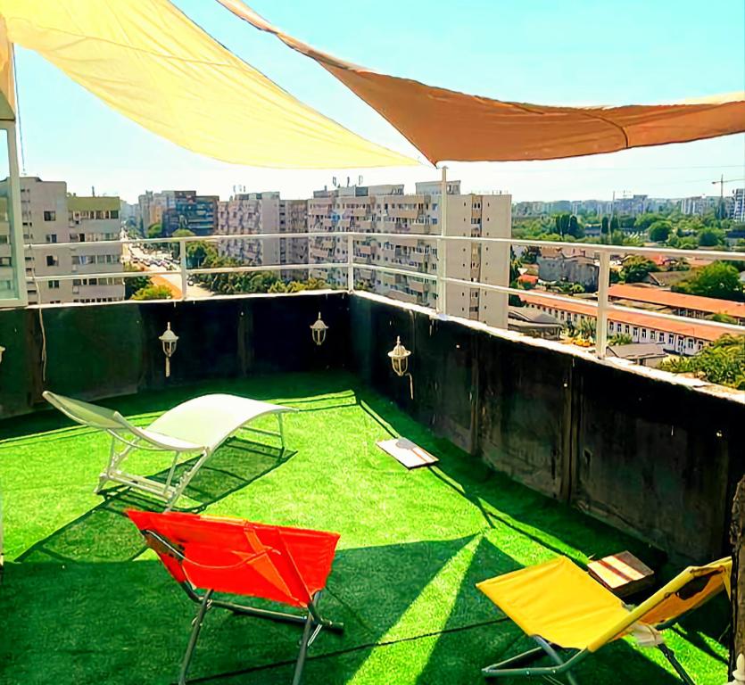 een balkon met stoelen en een gazon op het dak bij PTM One in Boekarest