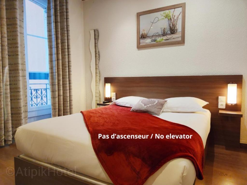 - une chambre avec un grand lit et une grande fenêtre dans l'établissement Atipik Hôtel, à Annecy