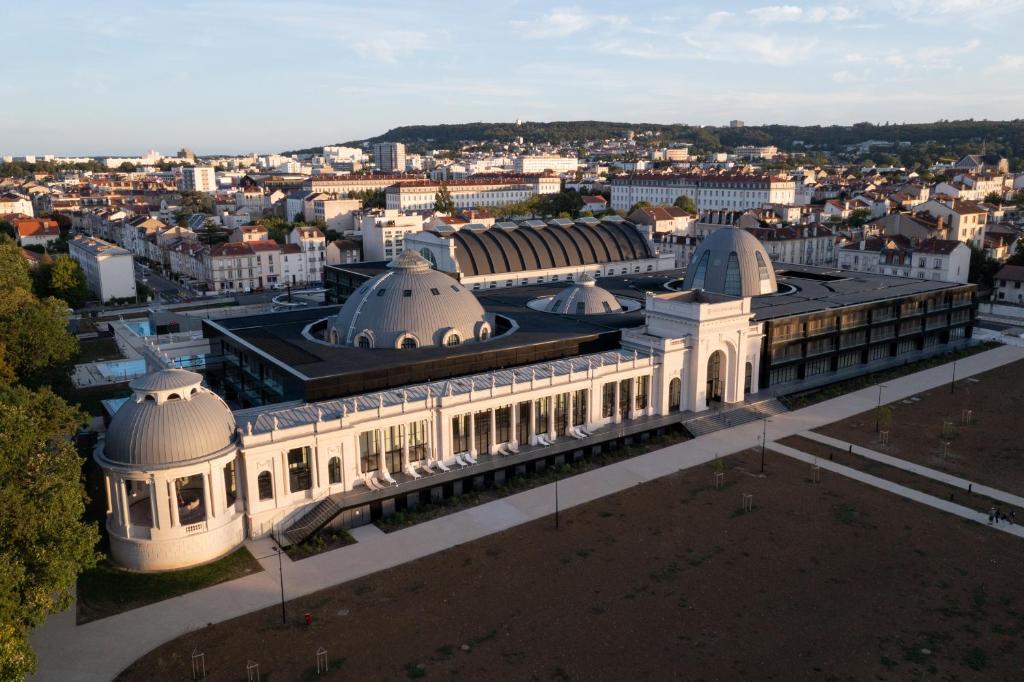 une vue aérienne d'un bâtiment avec une ville en arrière-plan dans l'établissement Villa Thermae Nancy, à Nancy