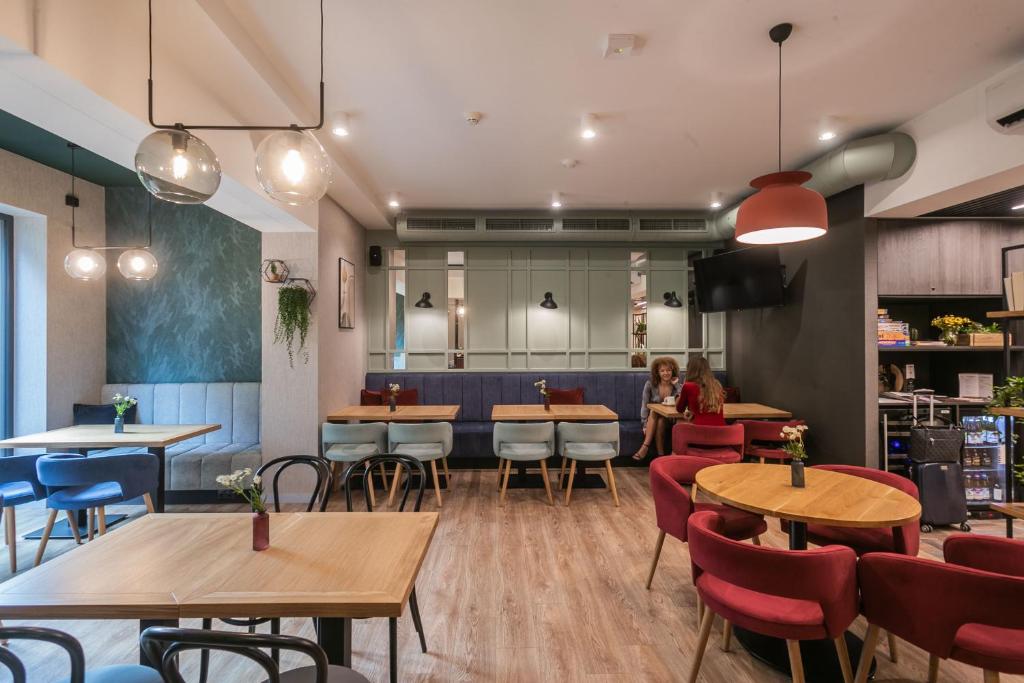 a restaurant with wooden tables and chairs and a bar at Hotel Vesper House in Gdańsk