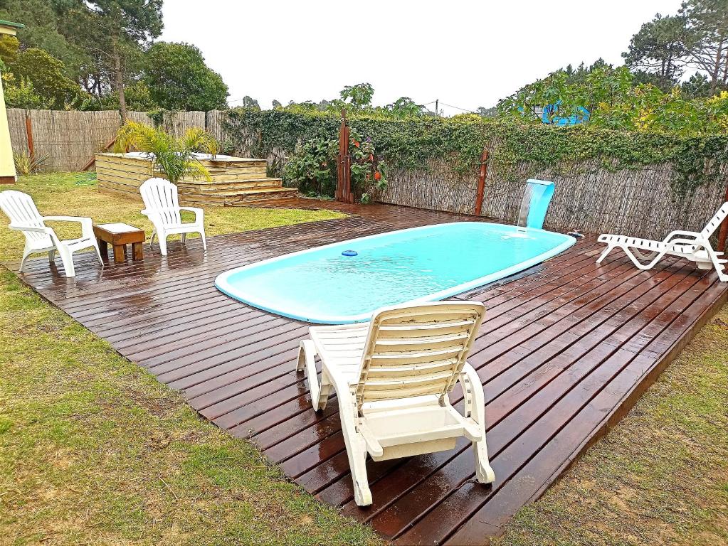 una piscina en una terraza con sillas y mesa en AMORES DEL DIABLO, en Punta del Diablo