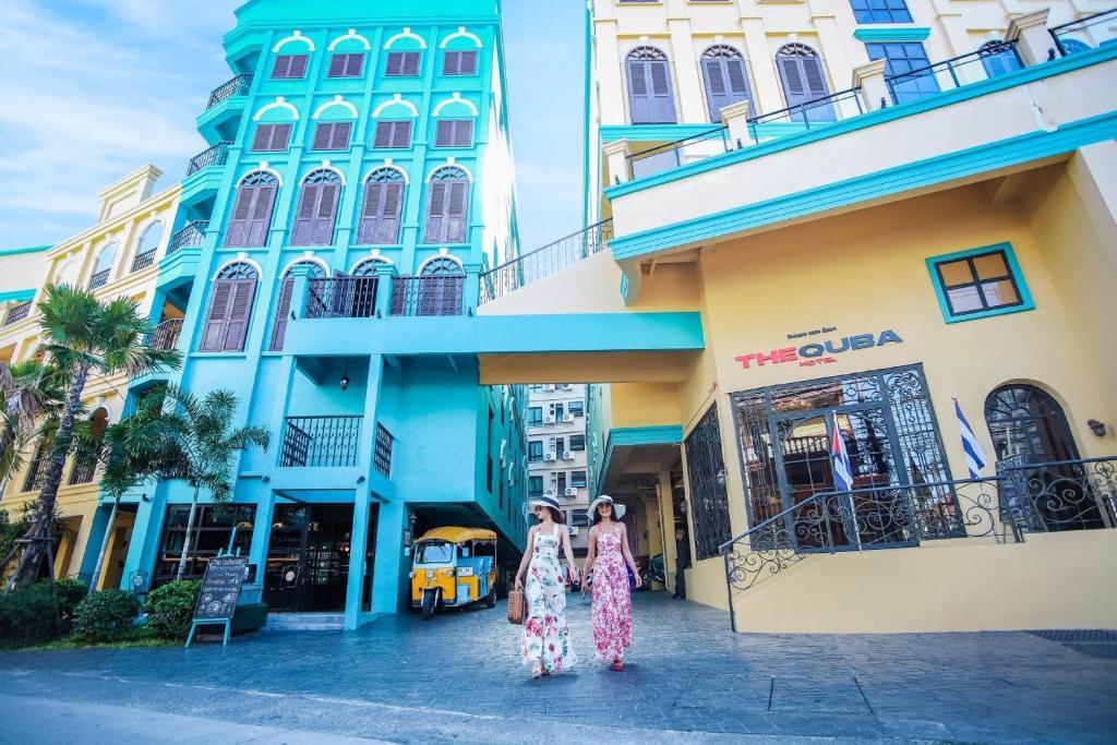 twee vrouwen die voor een gebouw lopen bij The Quba Boutique Hotel Pattaya in Pattaya