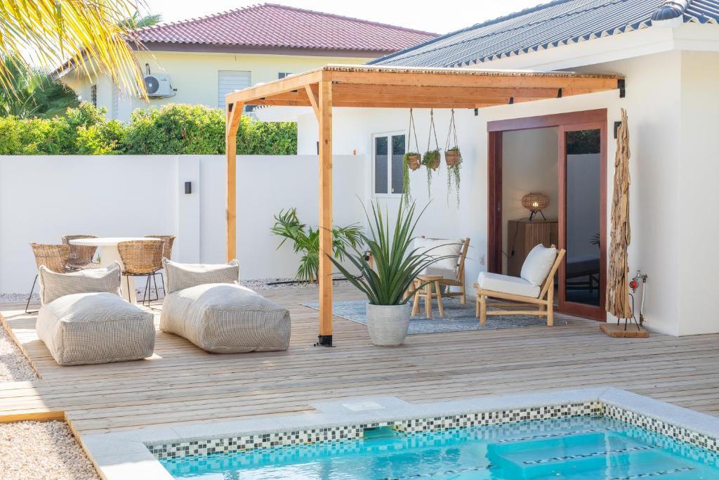 une terrasse arrière avec une piscine et une pergola dans l'établissement Appartement James, à Jan Thiel