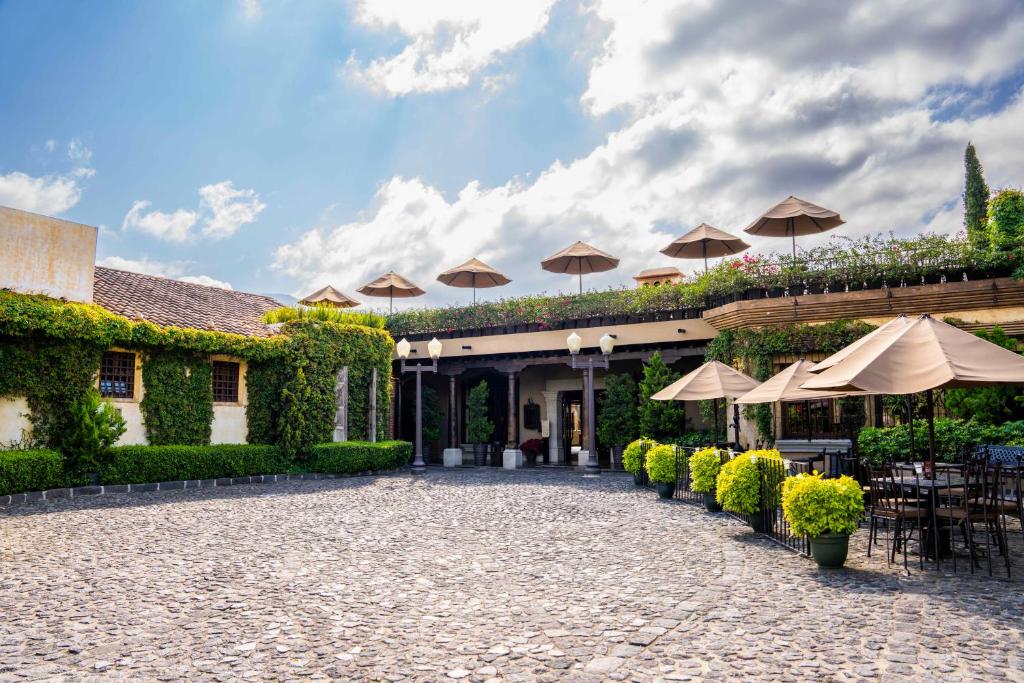 a courtyard with umbrellas and tables and chairs at Camino Real Antigua in Antigua Guatemala