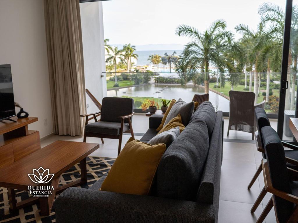 a living room with a couch and a view of the ocean at Beautiful Aria Ocean 401 QueridaEstancia in Nuevo Vallarta 