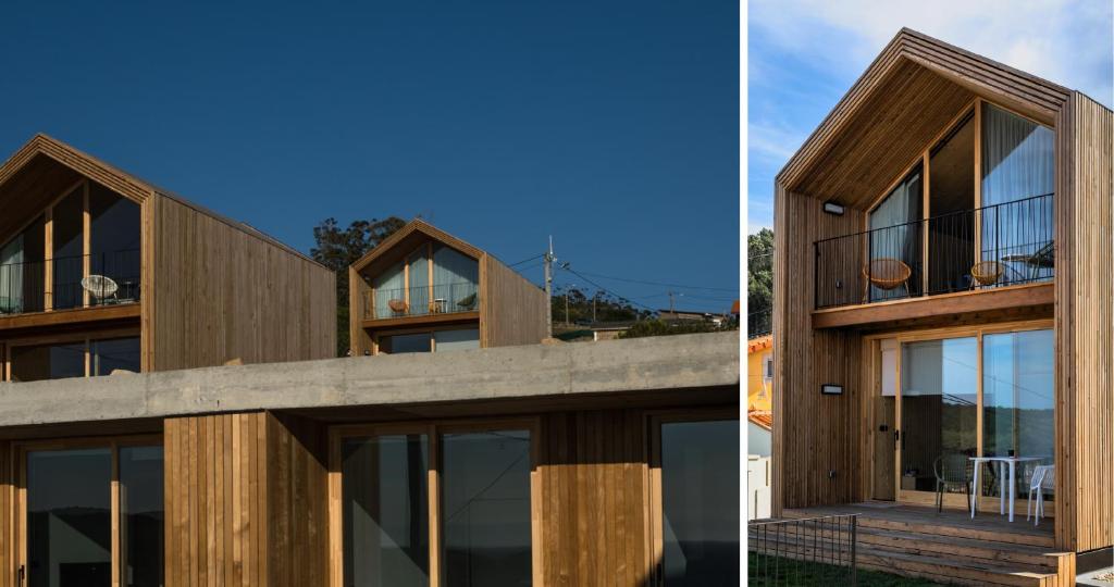 une maison en bois avec des fenêtres en verre et une terrasse dans l'établissement Doniños Nature, à La Corogne