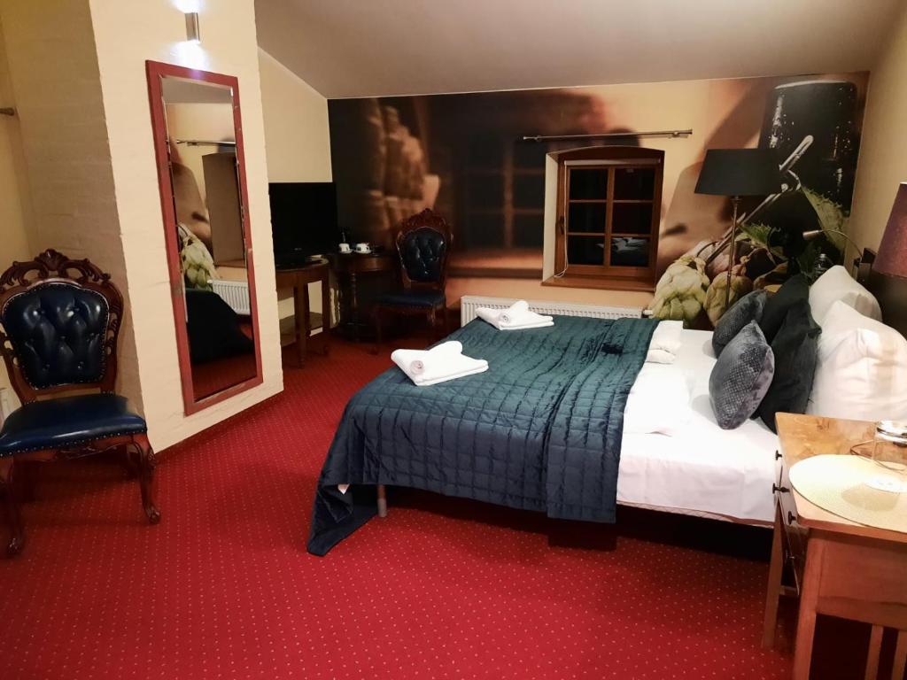 - une chambre d'hôtel avec un lit et un miroir dans l'établissement Hotel Spichrz, à Borcz