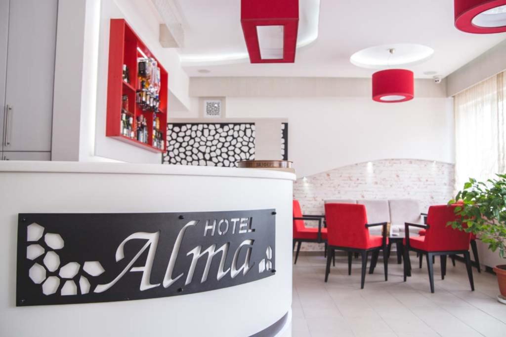 una sala da pranzo con tavolo e sedie rosse di Garni hotel Alma a Pirot