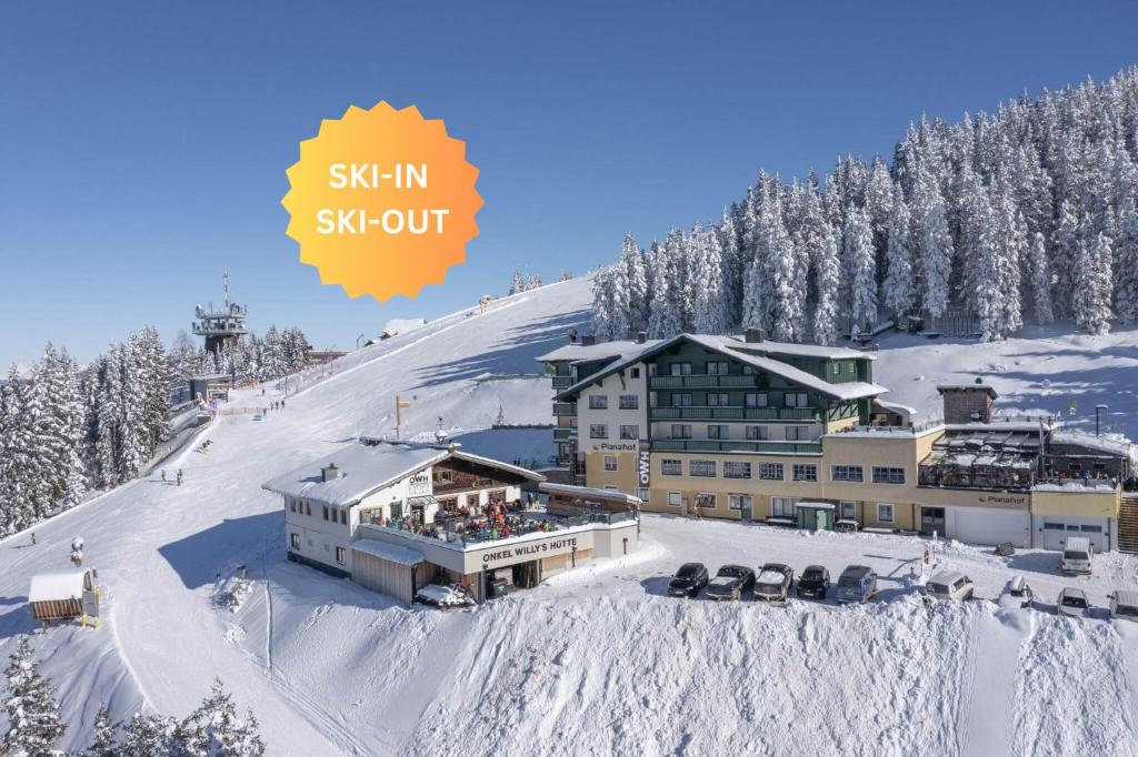 un lodge de ski sur une montagne enneigée avec des personnes sur le toit dans l'établissement Hotel-Restaurant Planaihof, à Schladming