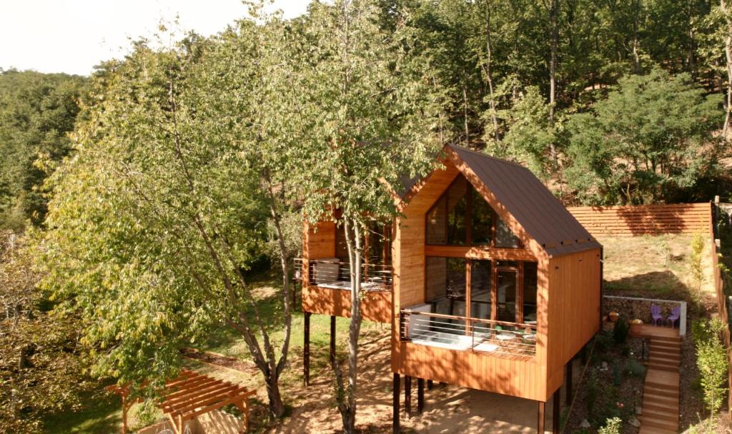 uma cabana na floresta ao lado de algumas árvores em Parádka - Toscana Villa em Parád