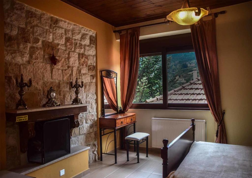 um quarto com uma cama, uma lareira e uma janela em Evergreen Suites em Synikia Mesi Trikalon