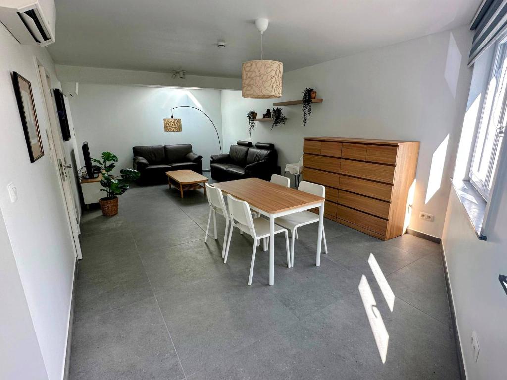 een woonkamer met een tafel en een bank bij Akuta City Flat Leuven in Leuven