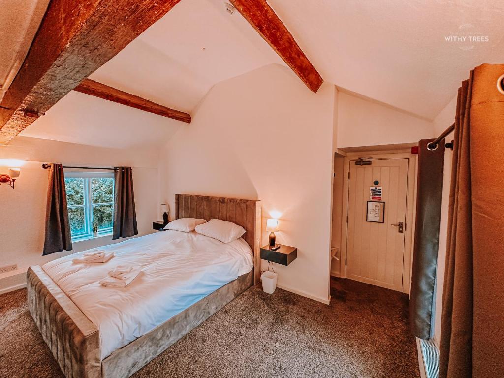 - une chambre avec un grand lit et une fenêtre dans l'établissement Ye Olde Original Withy Trees, à Bamber Bridge