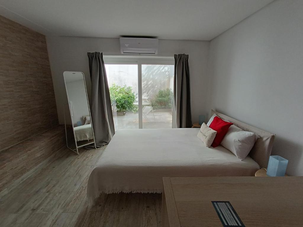 a bedroom with a large bed and a window at Tomarhousing - 37 Old Town in Tomar