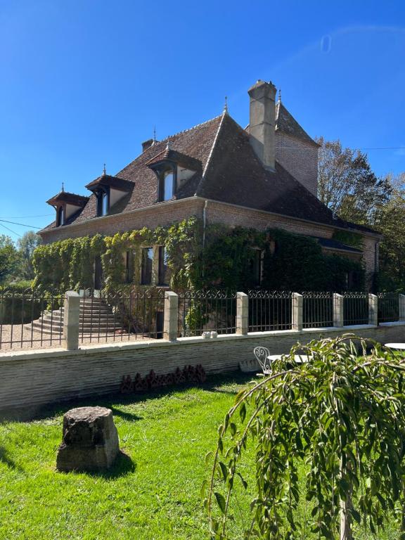 ein großes Haus mit einem Zaun und grünem Gras in der Unterkunft chambre d'hôtes Madame in Branges