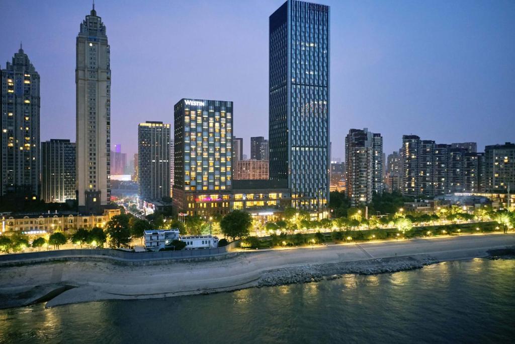 un perfil urbano por la noche con un río y edificios en The Westin Wuhan Wuchang, en Wuhan