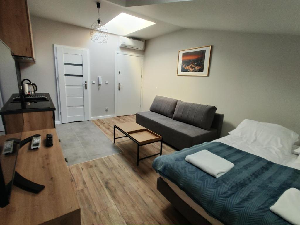 salon z łóżkiem i kanapą w obiekcie Apartamenty na Rynku Tarnów w Tarnowie