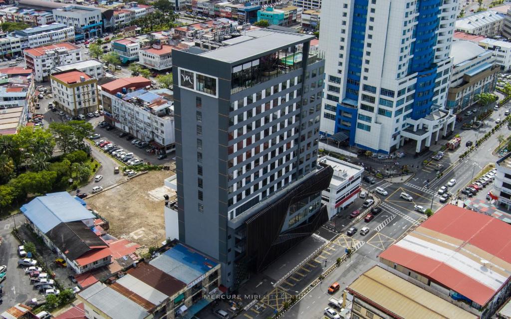 een uitzicht op een hoog gebouw in een stad bij Mercure Miri City Centre in Miri