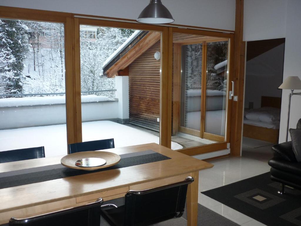 comedor con mesa, sillas y ventana en Moderne attraktive Dachwohnung für max. 6 Personen in ruhiger Umgebung, en Flims