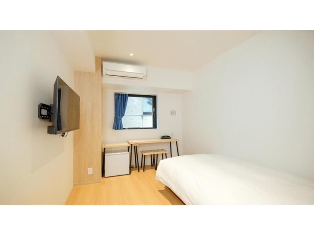 una camera con letto, tavolo e finestra di ELE HOTEL KUZUHA- Vacation STAY 80313v a Hirakata