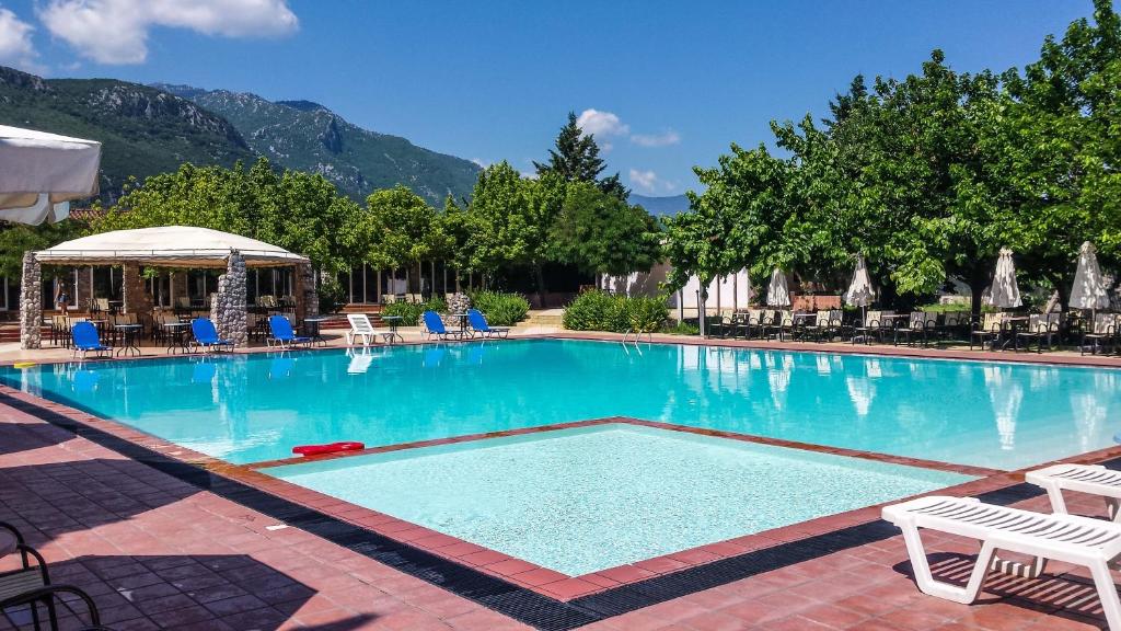 uma grande piscina com cadeiras e um gazebo em Pineas em Kalabaka