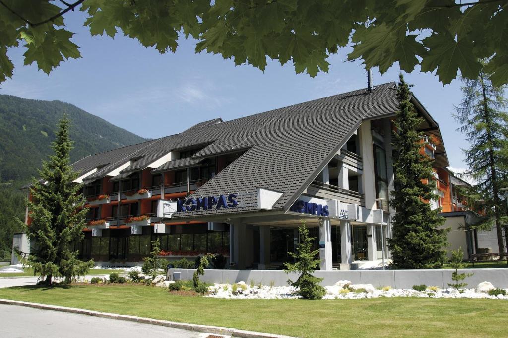 een groot gebouw met een zwart dak bij Hotel Kompas in Kranjska Gora