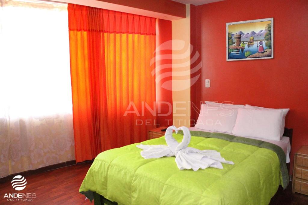 a bedroom with a bed with a towel on it at ANDENES DEL TITICACA in Puno