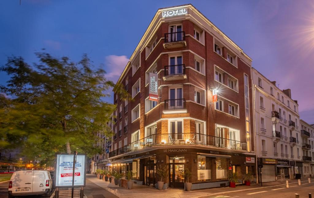 een gebouw in een straat met een busje aan de voorkant bij The Originals Boutique, Hôtel Le Marignan,Le Havre Centre Gare in Le Havre