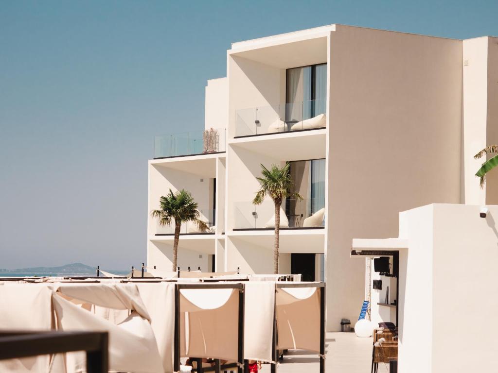 een gebouw met stoelen en palmbomen op een balkon bij Nobus Hotel & Spa in Vlorë