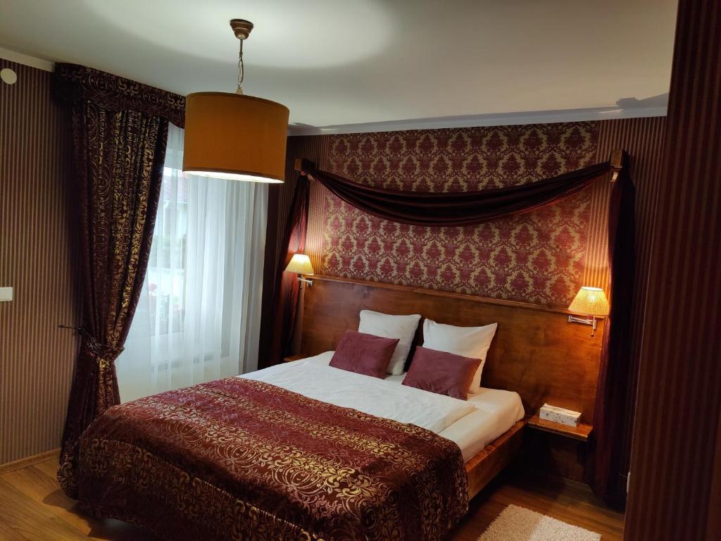 - une chambre avec un grand lit et une tête de lit en bois dans l'établissement Motelis SMAKŲ SMAKAS, à Šiauliai