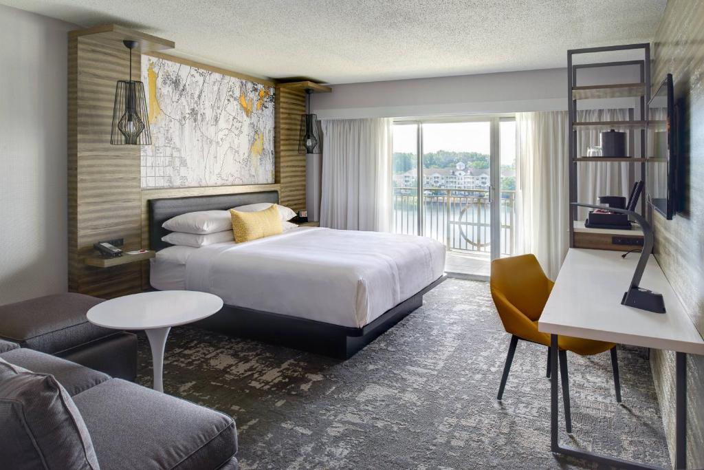 une chambre d'hôtel avec un lit et un canapé dans l'établissement Marriott Indianapolis North, à Indianapolis