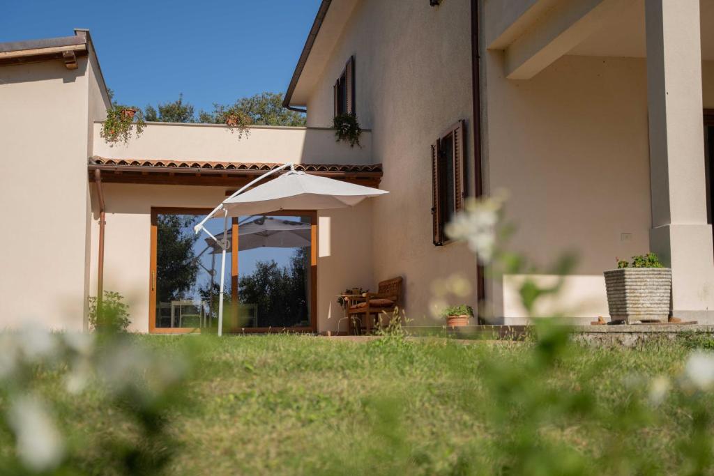 una casa con un ombrello davanti a un cortile di Poggio delle Ginestre a Orvieto