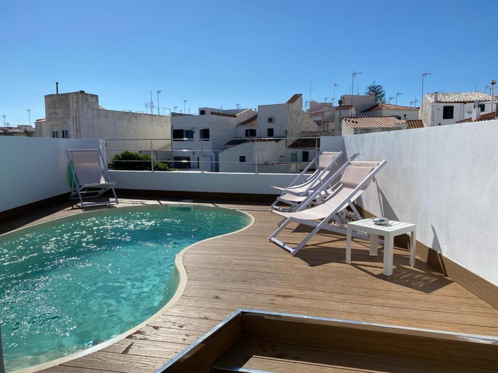 una terrazza con sedie e una piscina sul tetto di Casa S’Arraval a Mahón