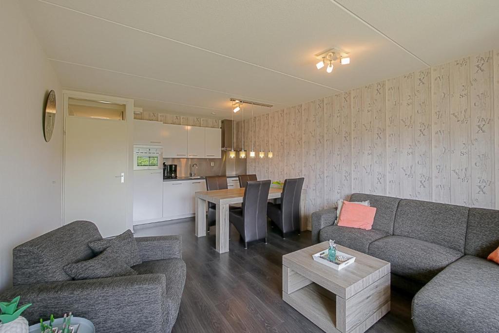 Il comprend un salon avec un canapé et une table. dans l'établissement Beach Appartement 14 - Callantsoog, à Callantsoog