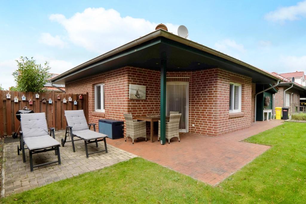 einem Pavillon mit Stühlen und einem Tisch im Hof in der Unterkunft Ferienhaus Nordlicht in Geeste