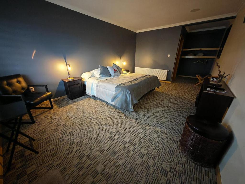 Habitación de hotel con cama y silla en SHEUEN PATAGONIA, en Puerto Natales