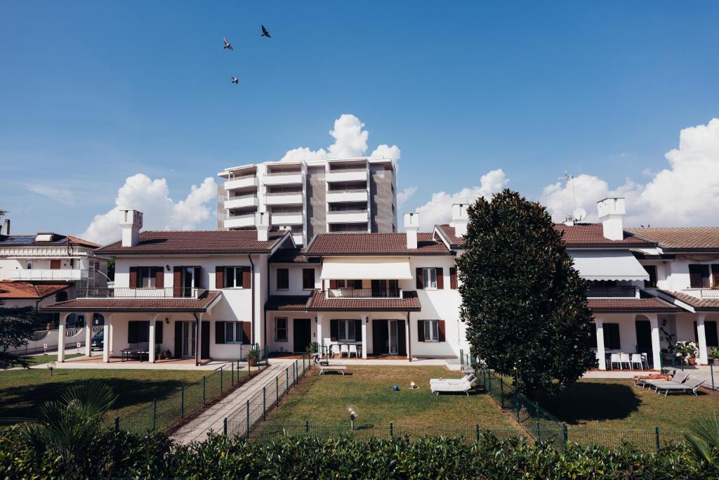 a group of houses with a tall building in the background at Anima Jesolo - Ca' delle Rose in Lido di Jesolo