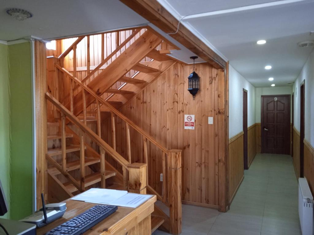 un bureau avec un escalier en bois et un bureau avec un clavier dans l'établissement Hostal JC, à Puerto Natales