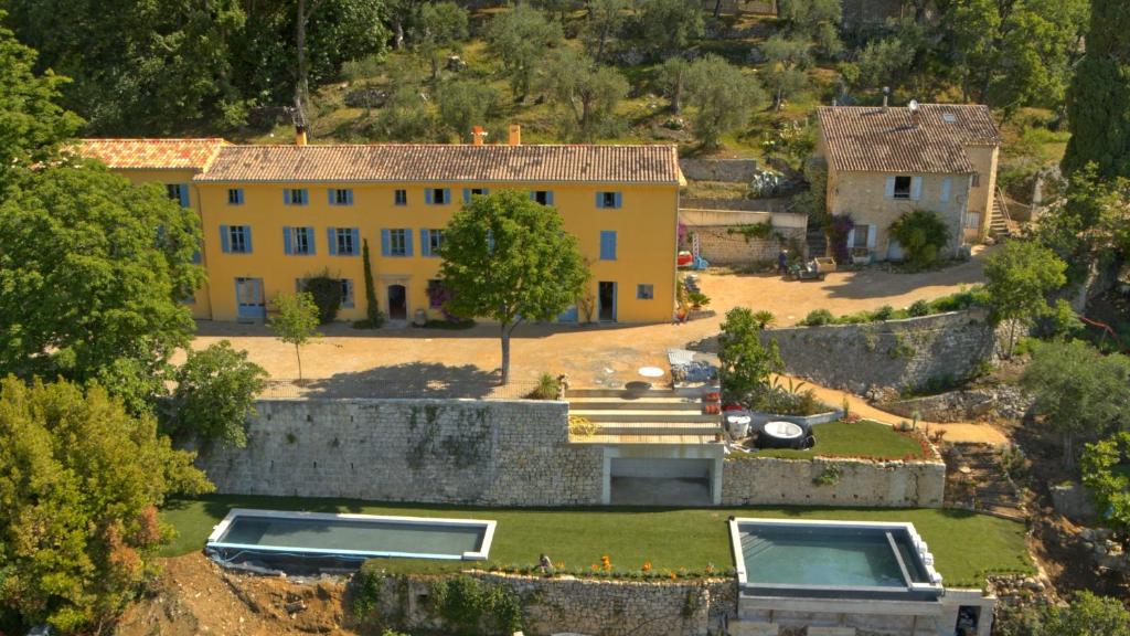 eine Luftansicht eines gelben Hauses mit einem Hof in der Unterkunft Domaine de la Cascade Parfumée in Grasse