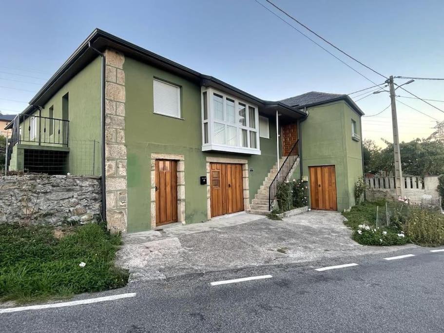 une maison verte avec des portes en bois dans une rue dans l'établissement Casa da Baltasara, à Trives