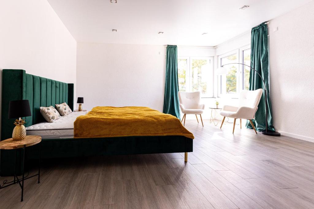 een slaapkamer met een groot bed en groene gordijnen bij Design Apartment zentral für 6 in Andernach: Ausblick, WiFi, Küche in Andernach