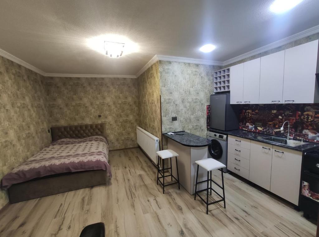 a small bedroom with a bed and a kitchen at gabro in Mtskheta