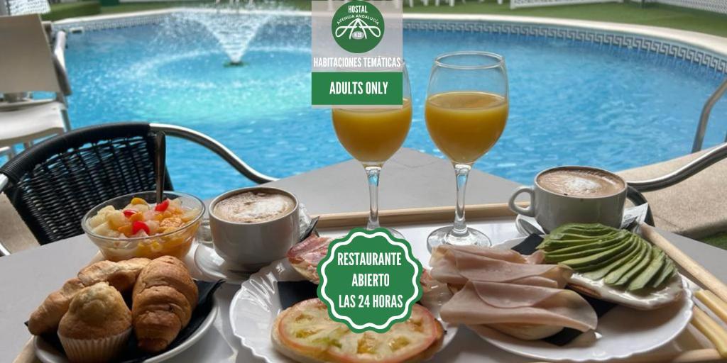 un tavolo con vassoio di cibo e due bicchieri di succo d'arancia di Hostal Avenida Andalucia - Solo Adultos a Siviglia